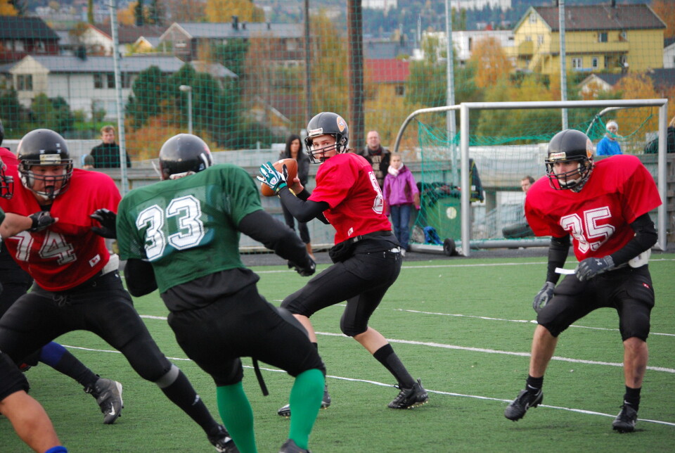 KASTET TIL LØVENE: HIST-student Atle Lindstad (i midten med ball) debuterte som quarterback for Lerkendal Lions i premieren på årets DFL-serie i amerikansk fotball.