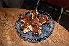 Dekorativt glassfat med brun glasert dessert på et trebord.